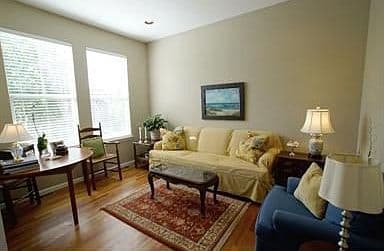 Bright living room with hardwoods and oversized windows.