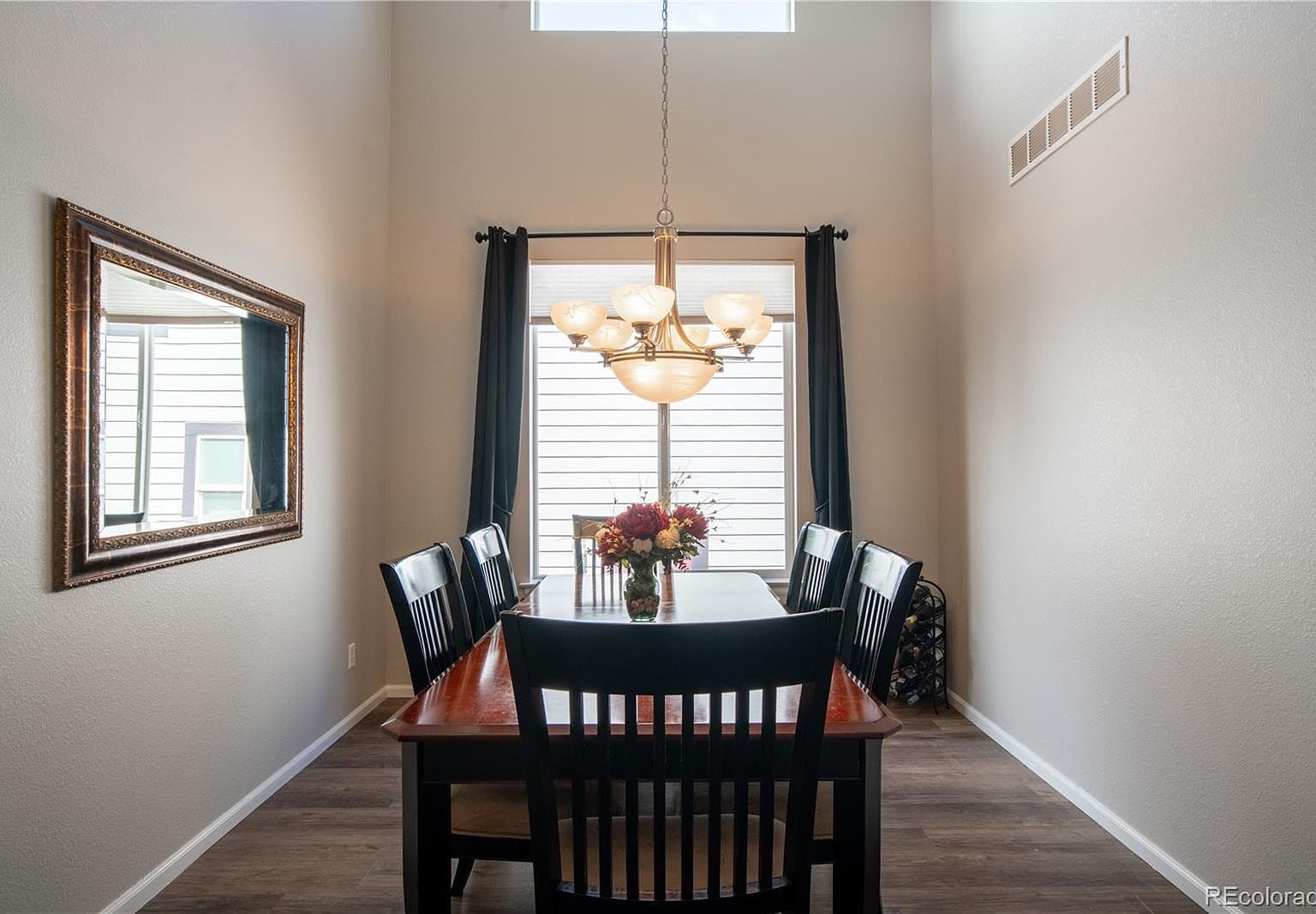Vaulted dining room filled with light and elegant chandelier.
