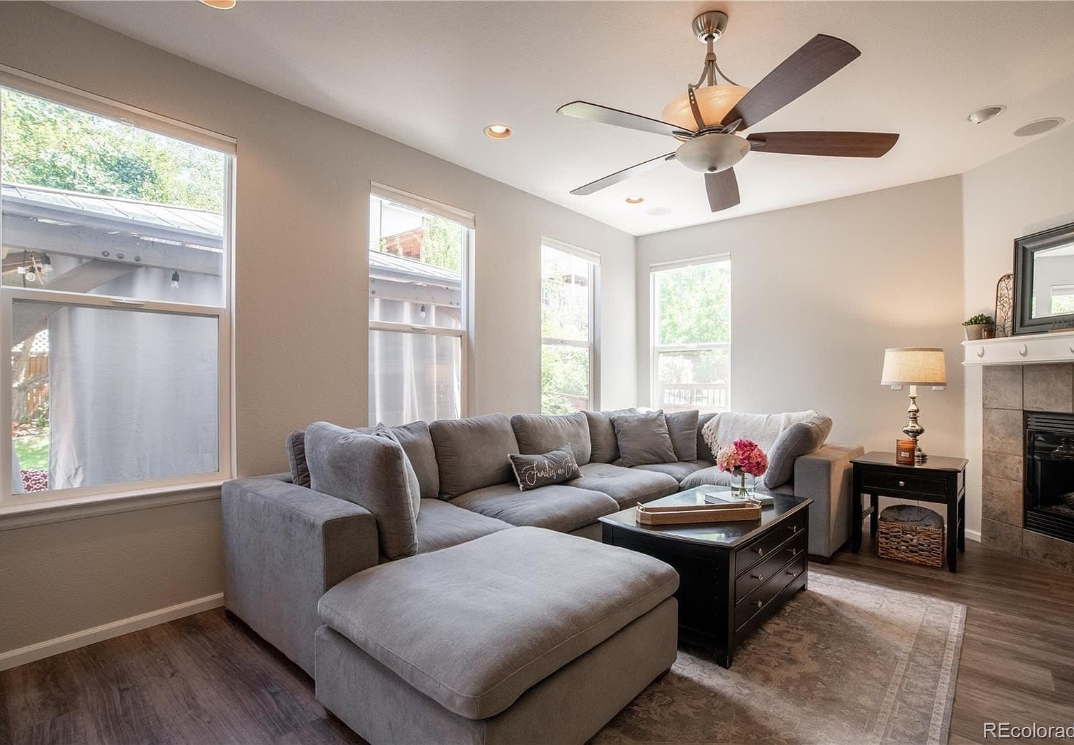 Sunlit family room with fireplace and soaring windows.