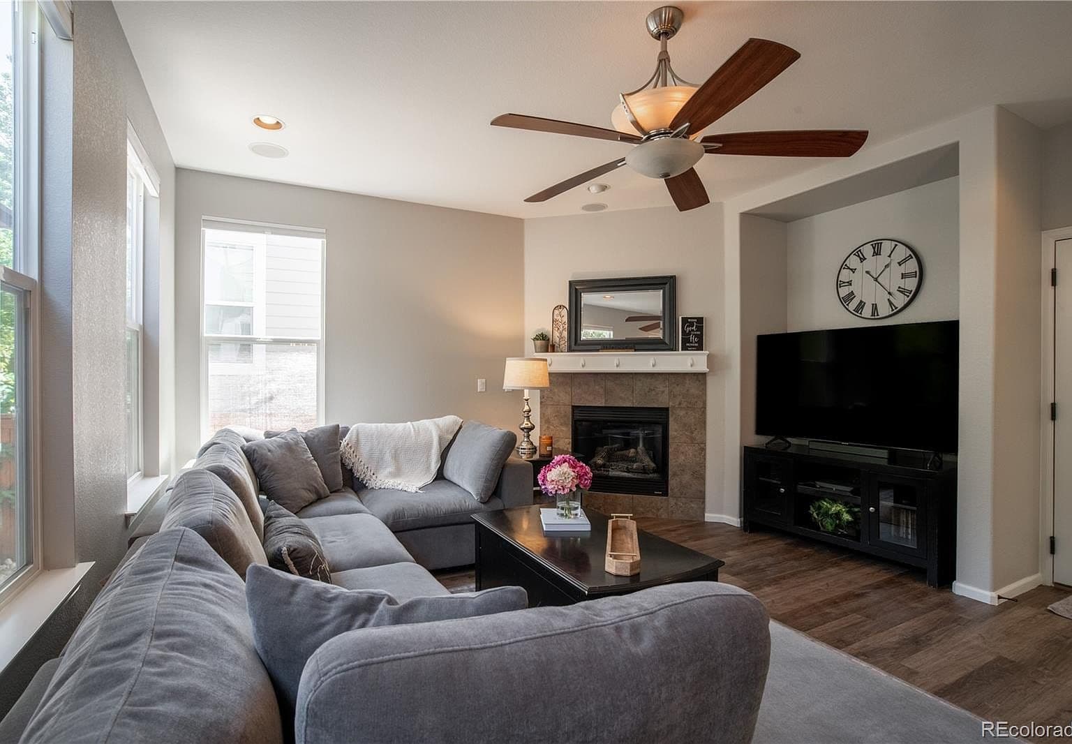 Cozy living space with gas fireplace and ceiling fan.