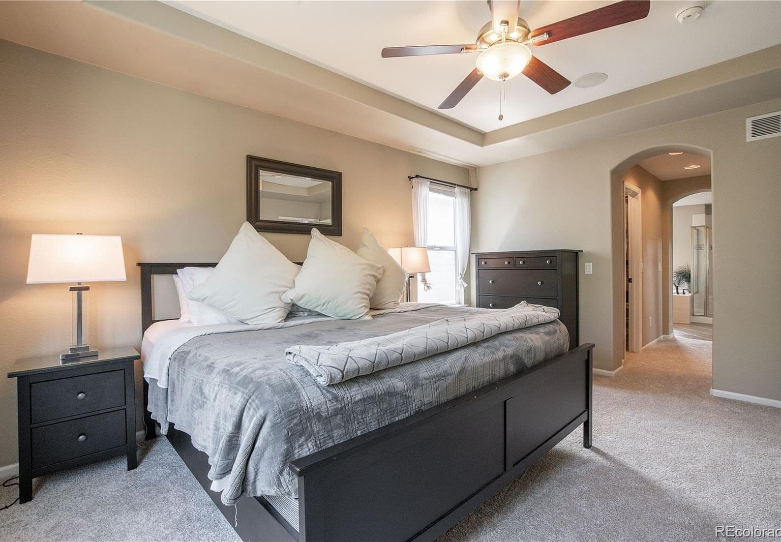 Bright primary bedroom with private bath hallway access.