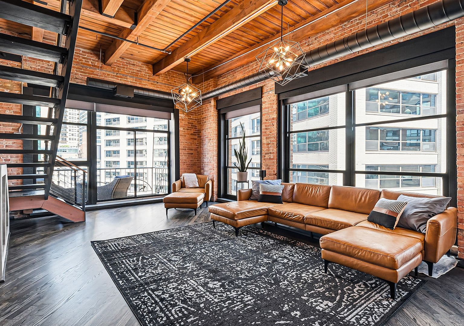 Dramatic loft living room with 13-ft timber ceilings and exposed brick