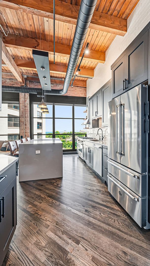 Chef's kitchen with quartz island and paneled stainless refrigerator