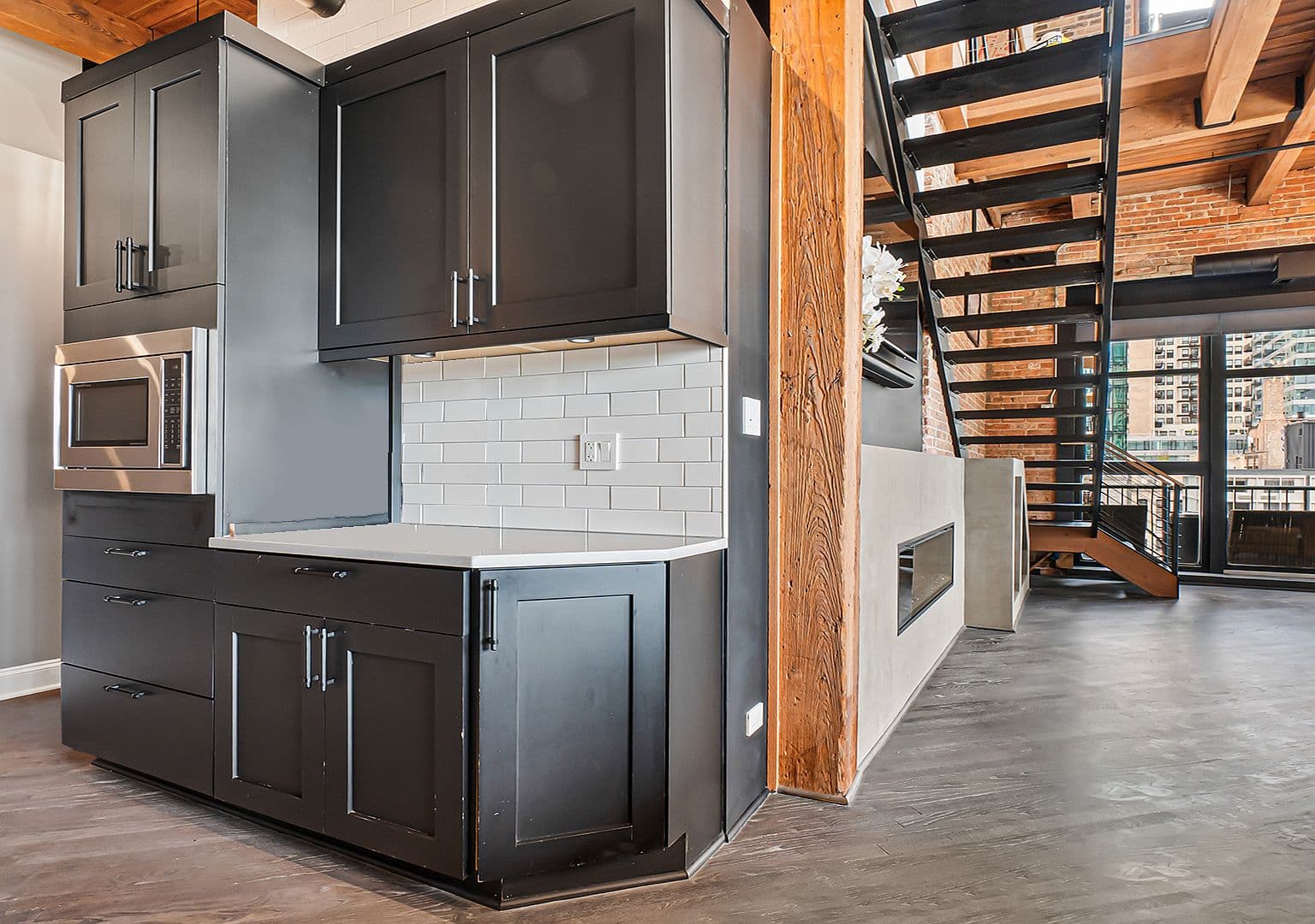 Custom matte-black cabinetry with built-in microwave and coffee station