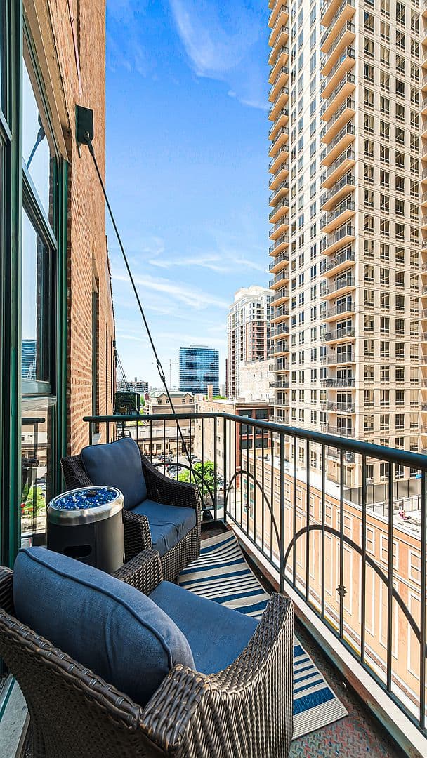 Private balcony with cozy seating and city skyline views