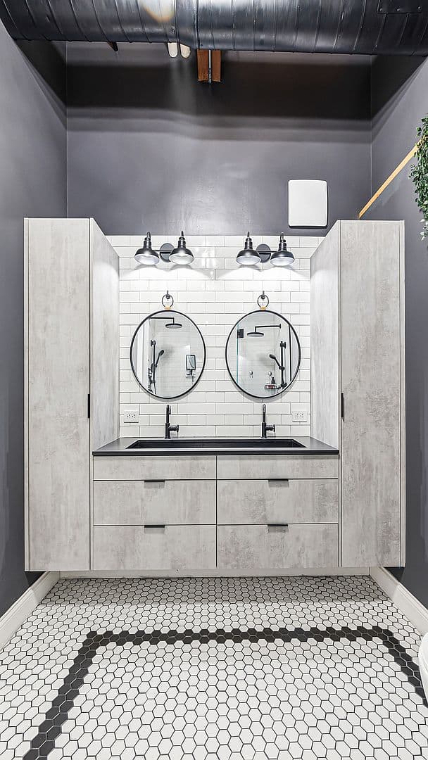 Double vanity with round mirrors and hex-tile floors