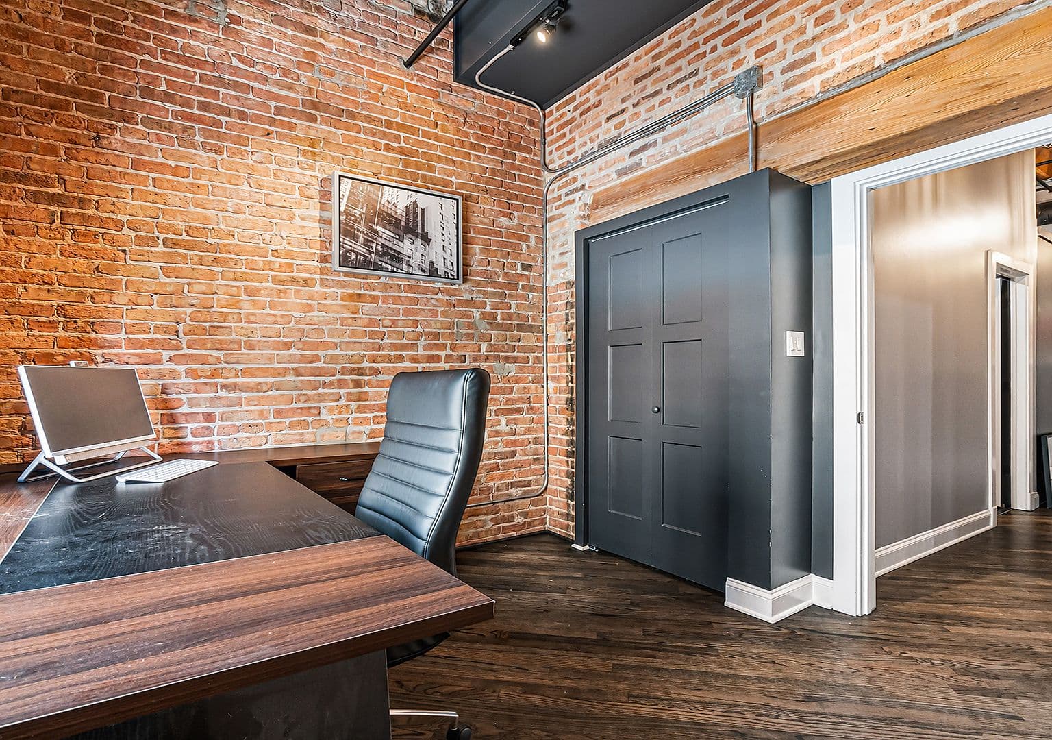 Home office corner with brick walls and closet storage