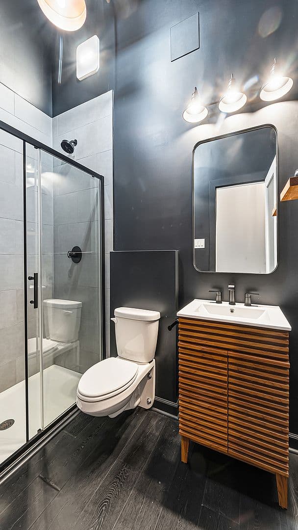 Sleek guest bath with teak vanity and glass shower
