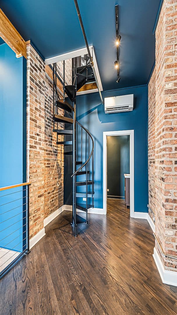 Black spiral staircase ascending to the third-level loft
