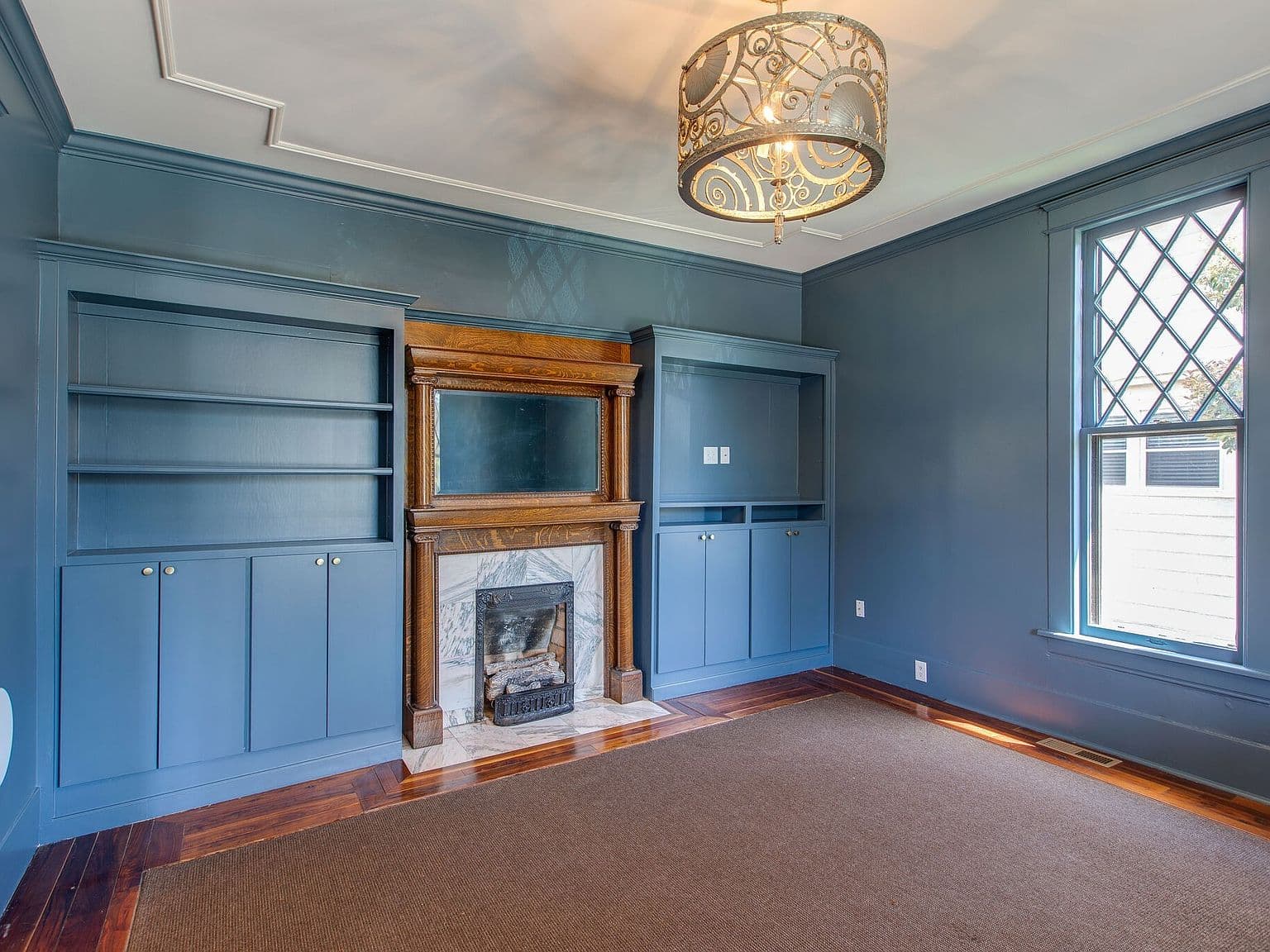 Dramatic built-ins and original marble fireplace centerpiece.