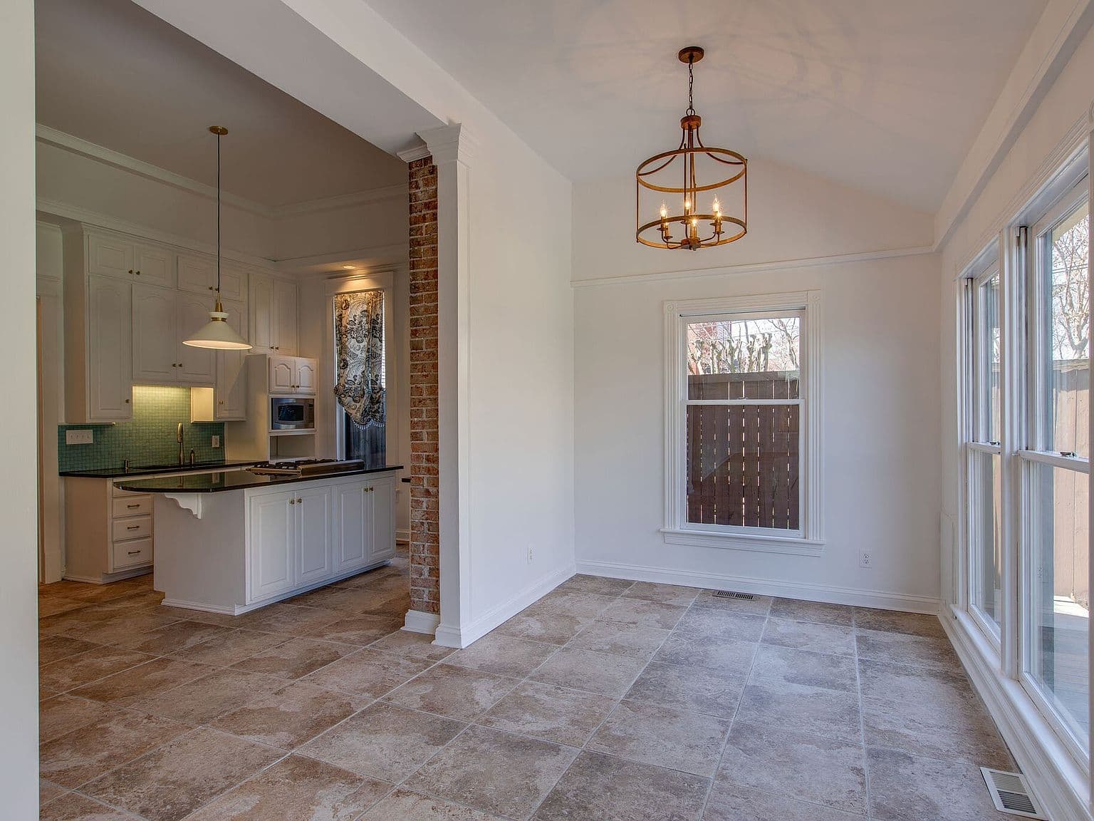 Bright dining nook with vaulted ceiling and generous windows.