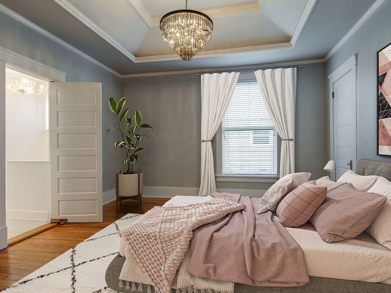 Serene primary bedroom with tray ceiling and heart-pine floors.