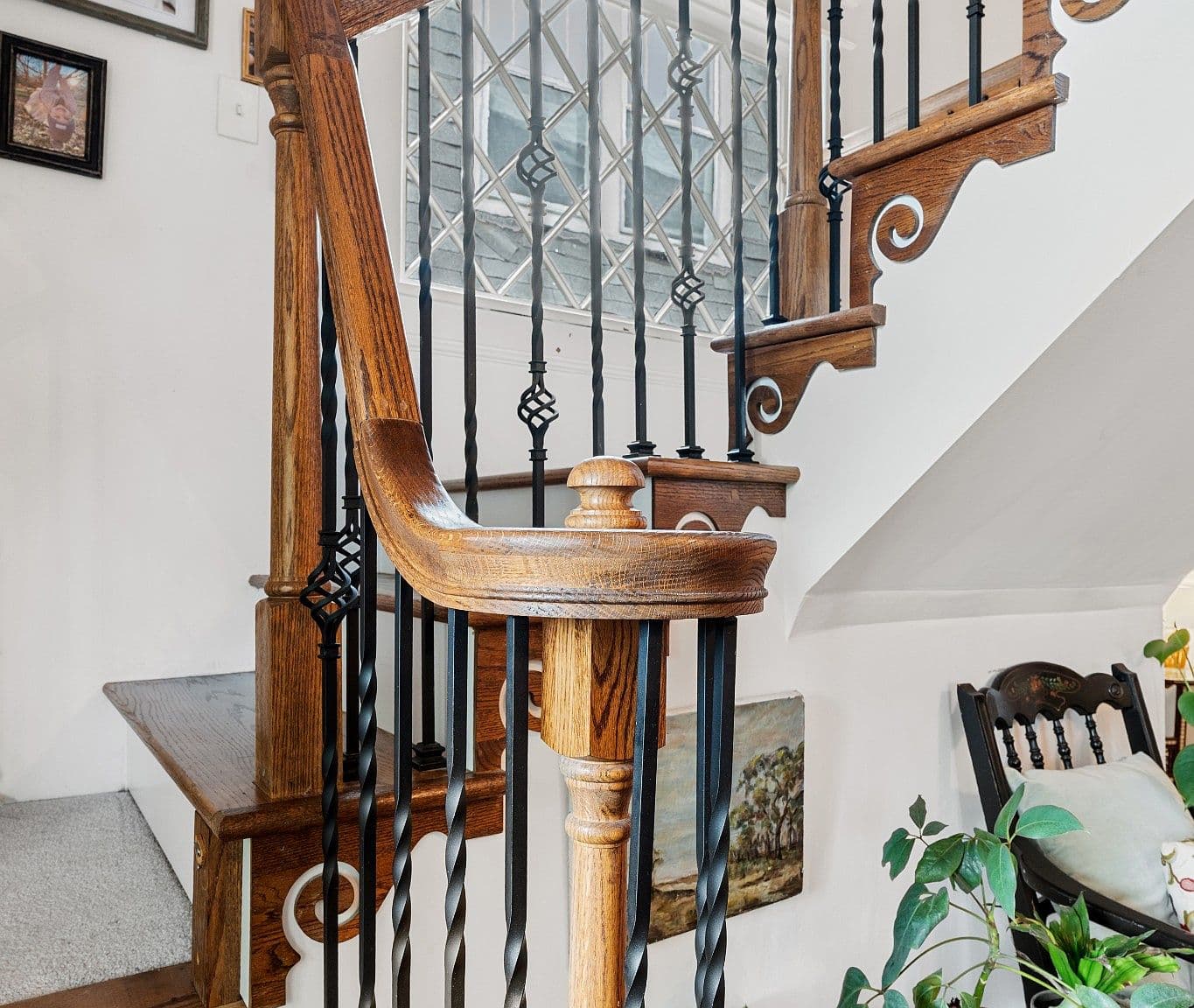 Craftsmanship shines in the stair newel and iron balusters.