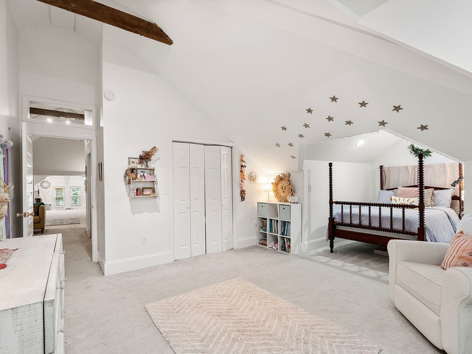 Light-filled upstairs space with charming chandelier and beam.