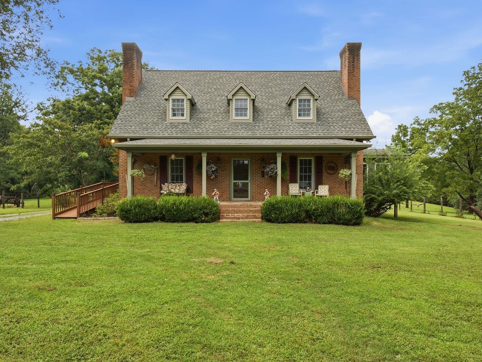 Classic brick farmhouse with inviting covered front porch.