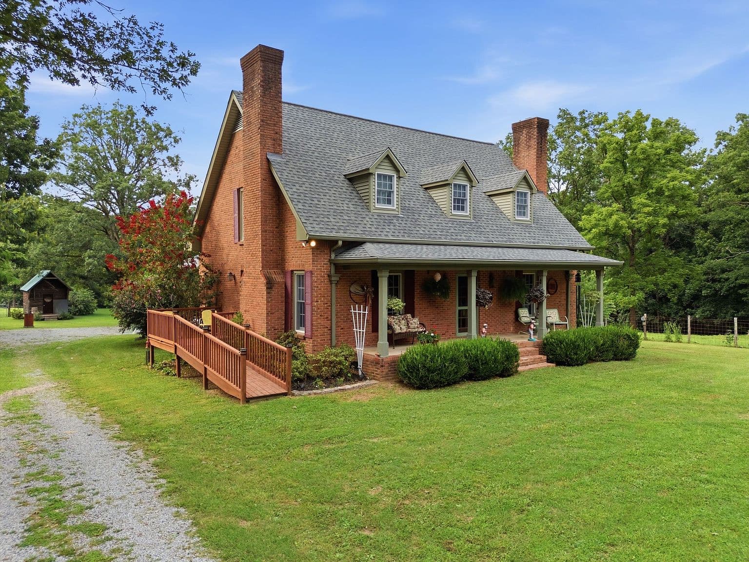 Side approach showcases ramped access and wraparound porch charm.