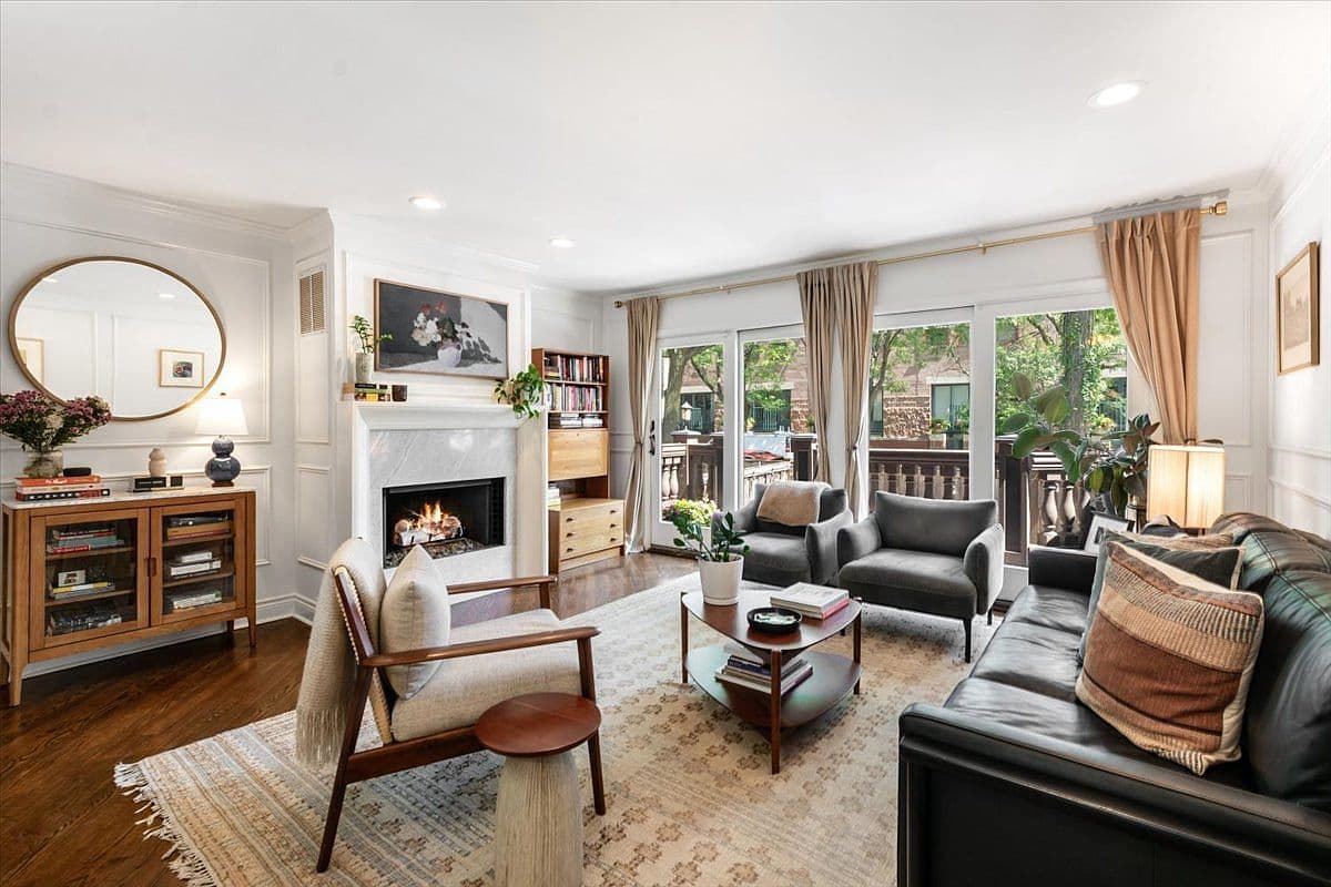 Sunlit living room with gas fireplace and deck doors.