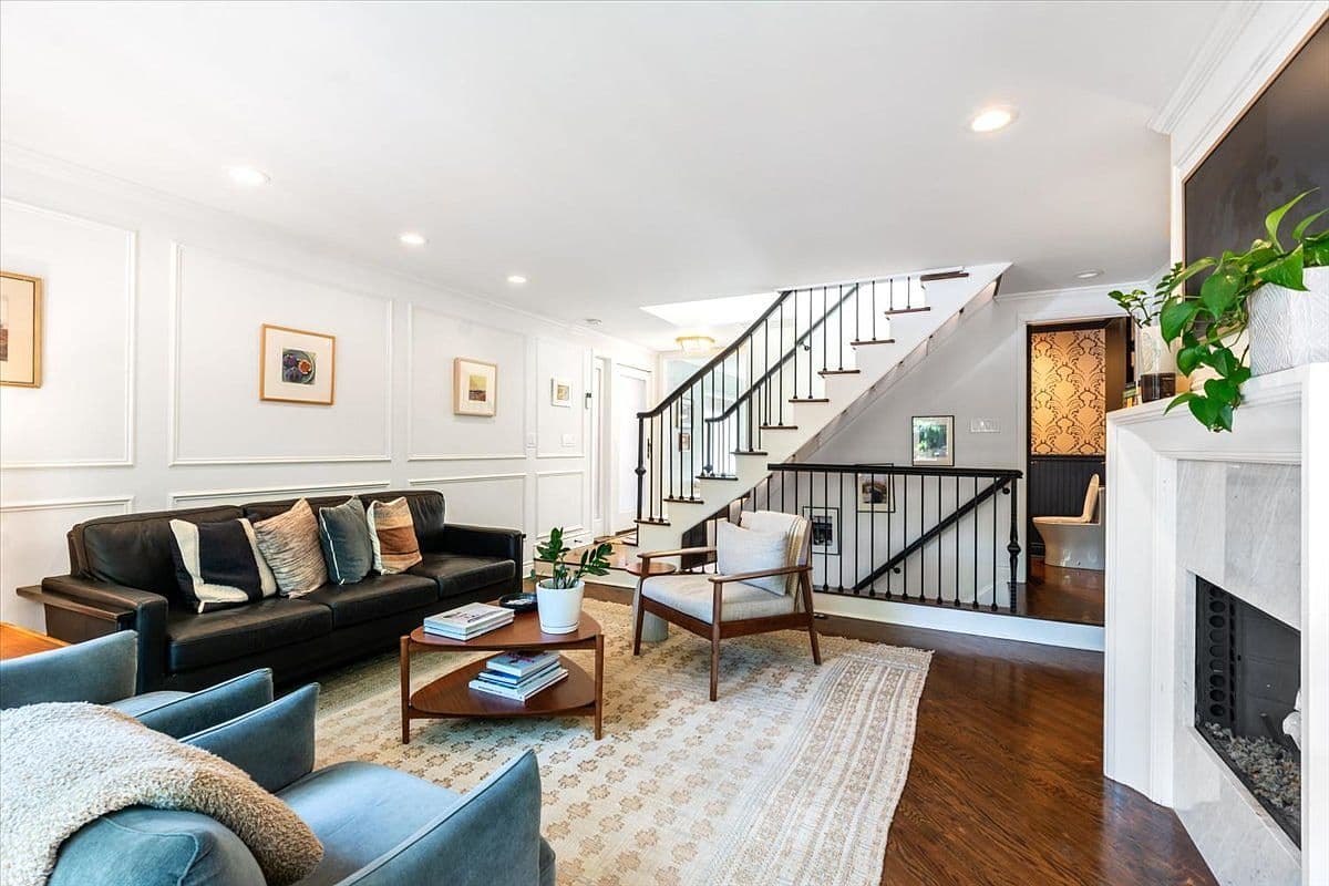 Custom paneled walls and curved stair create designer living space.