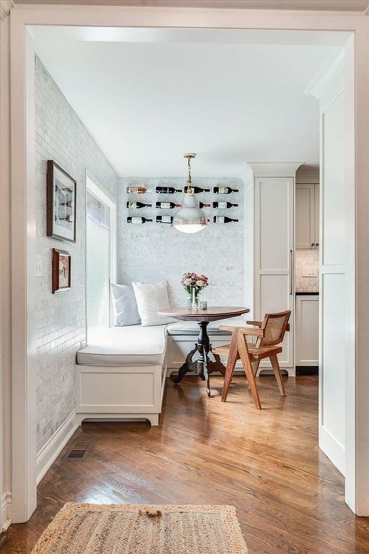 Inviting breakfast alcove framed by marble walls and warm hardwoods.
