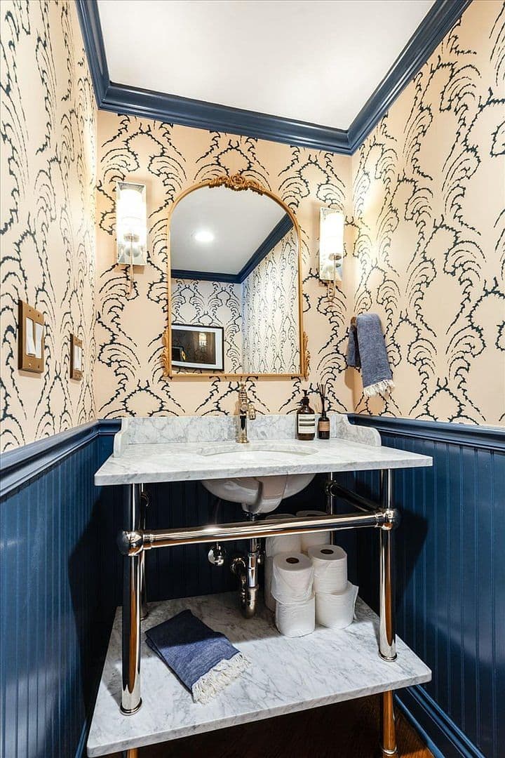 Designer powder room with bold wallpaper and marble vanity.