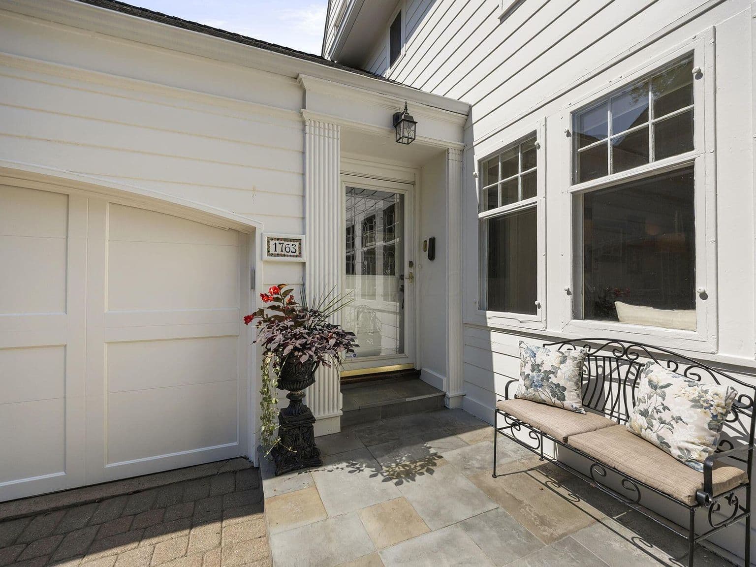 Inviting side entry with slate stoop and bench seating.