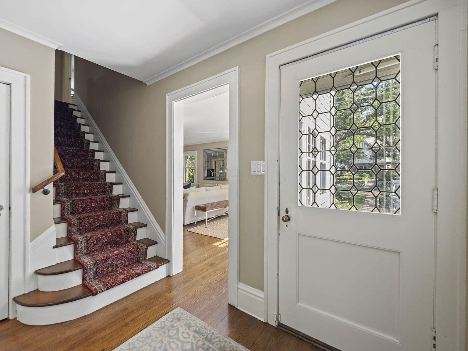 Elegant stairway welcomes you with rich runner and hardwoods.