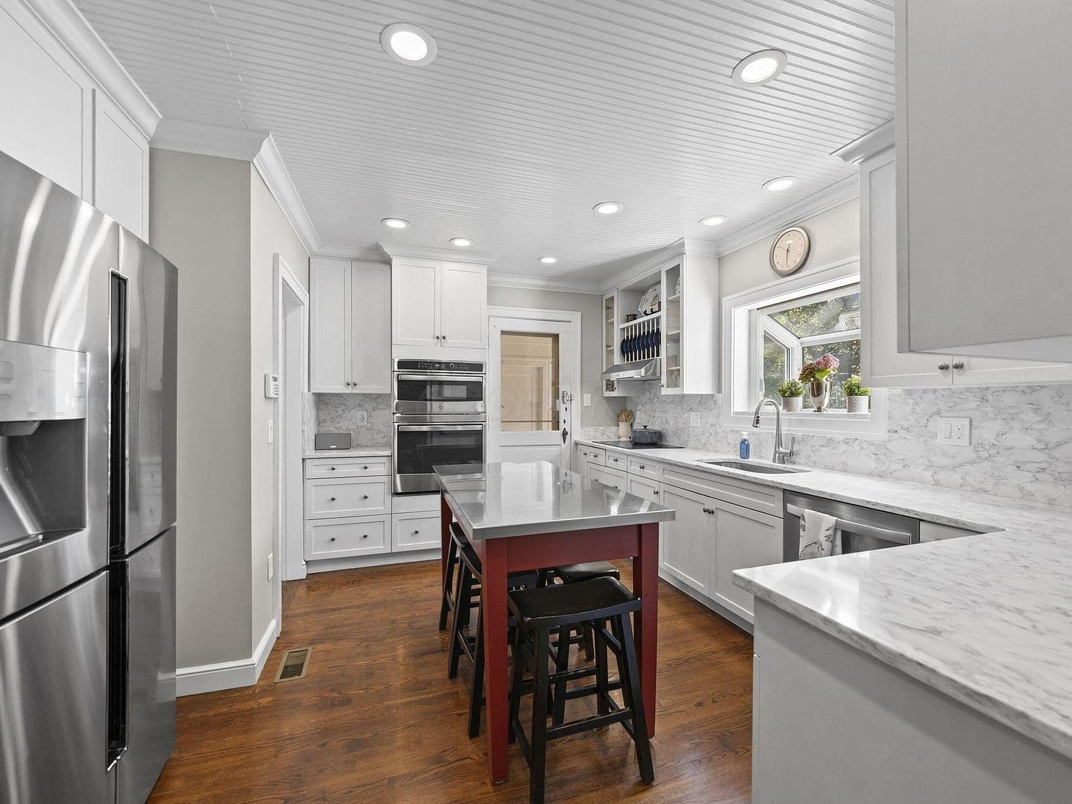 Chef’s kitchen with marble counters and oversized prep island.
