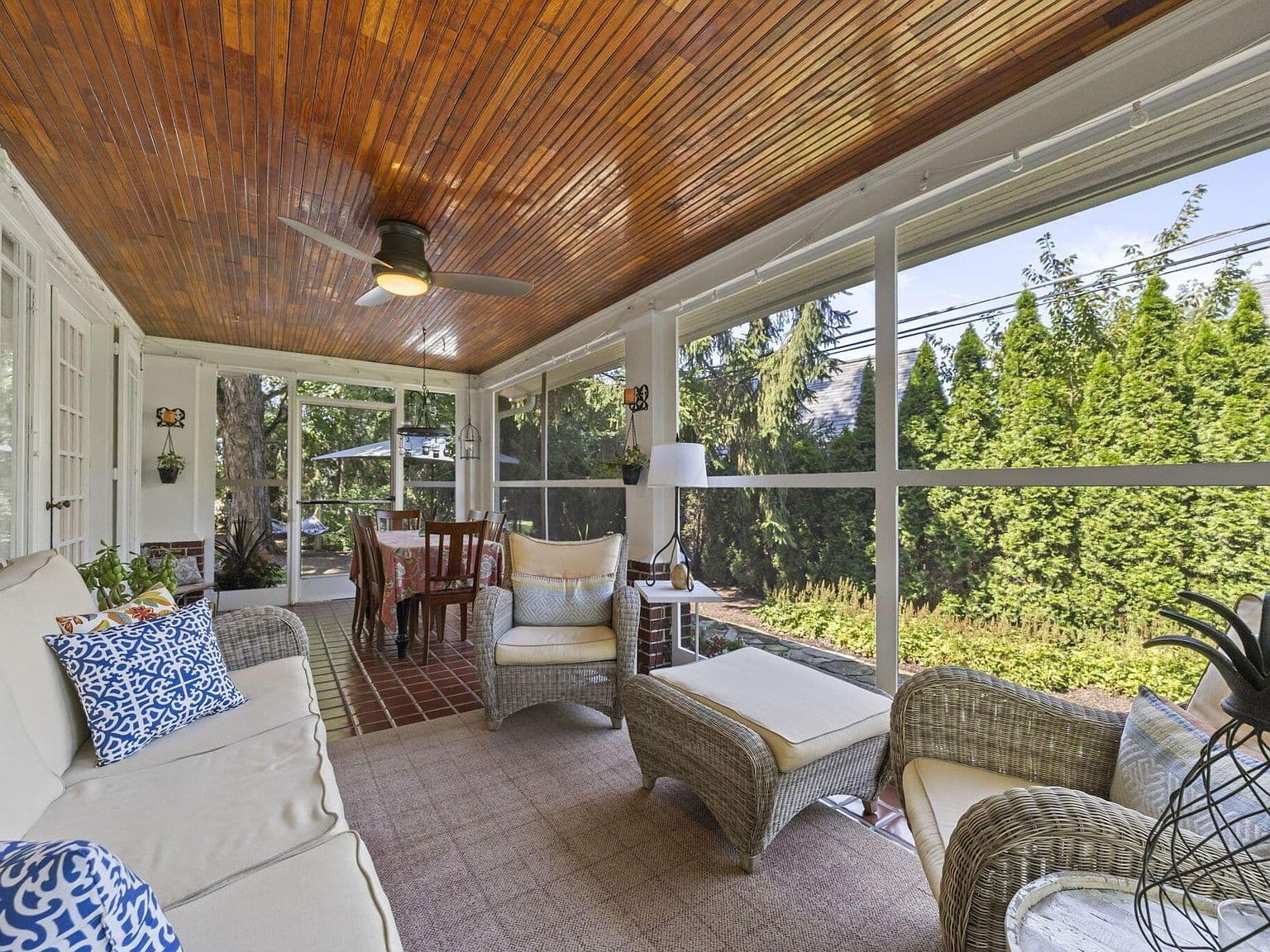 Spacious screened porch seating amid lush, private greenery.
