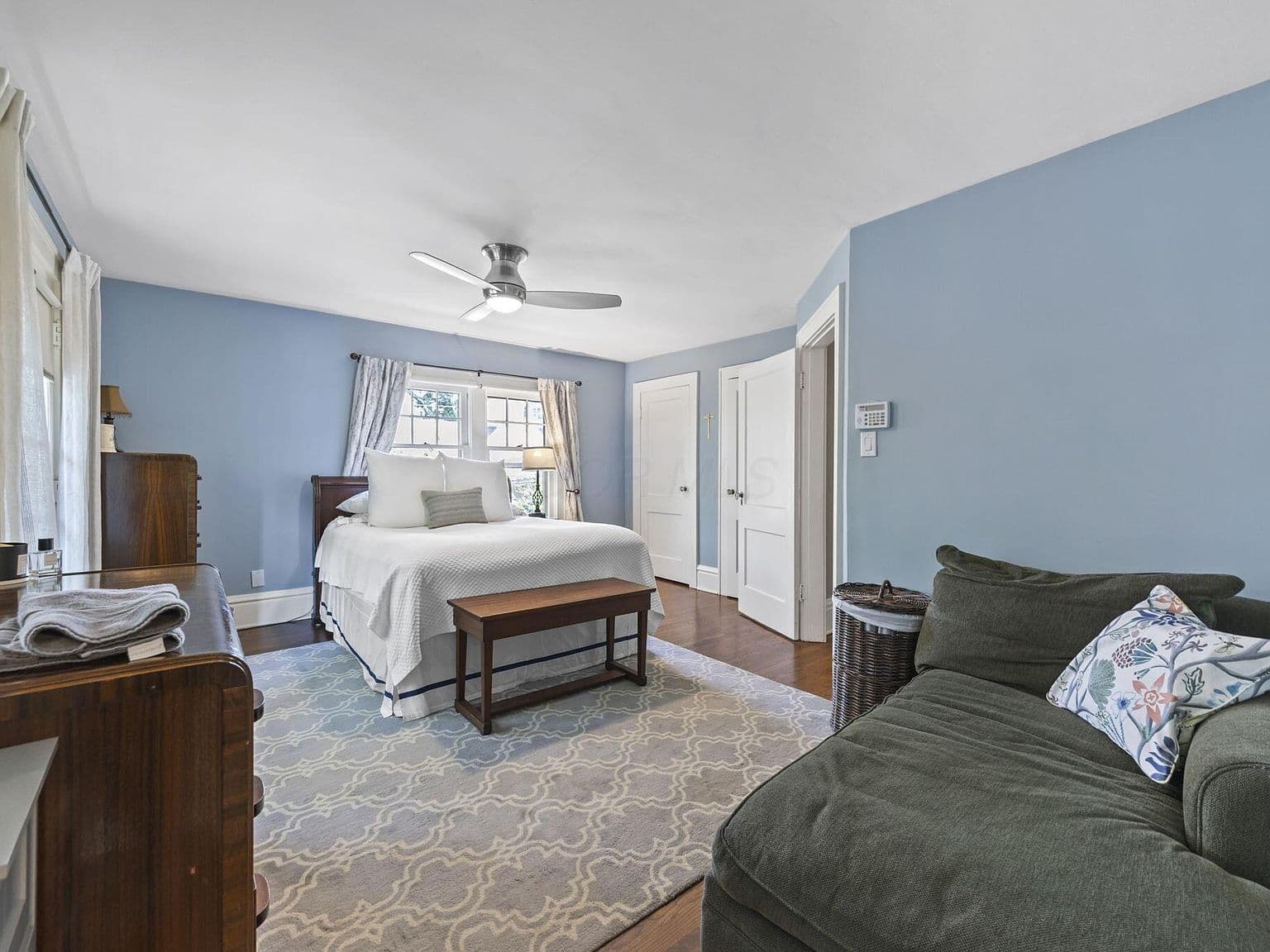 Spacious primary suite with lounge nook and soft light.