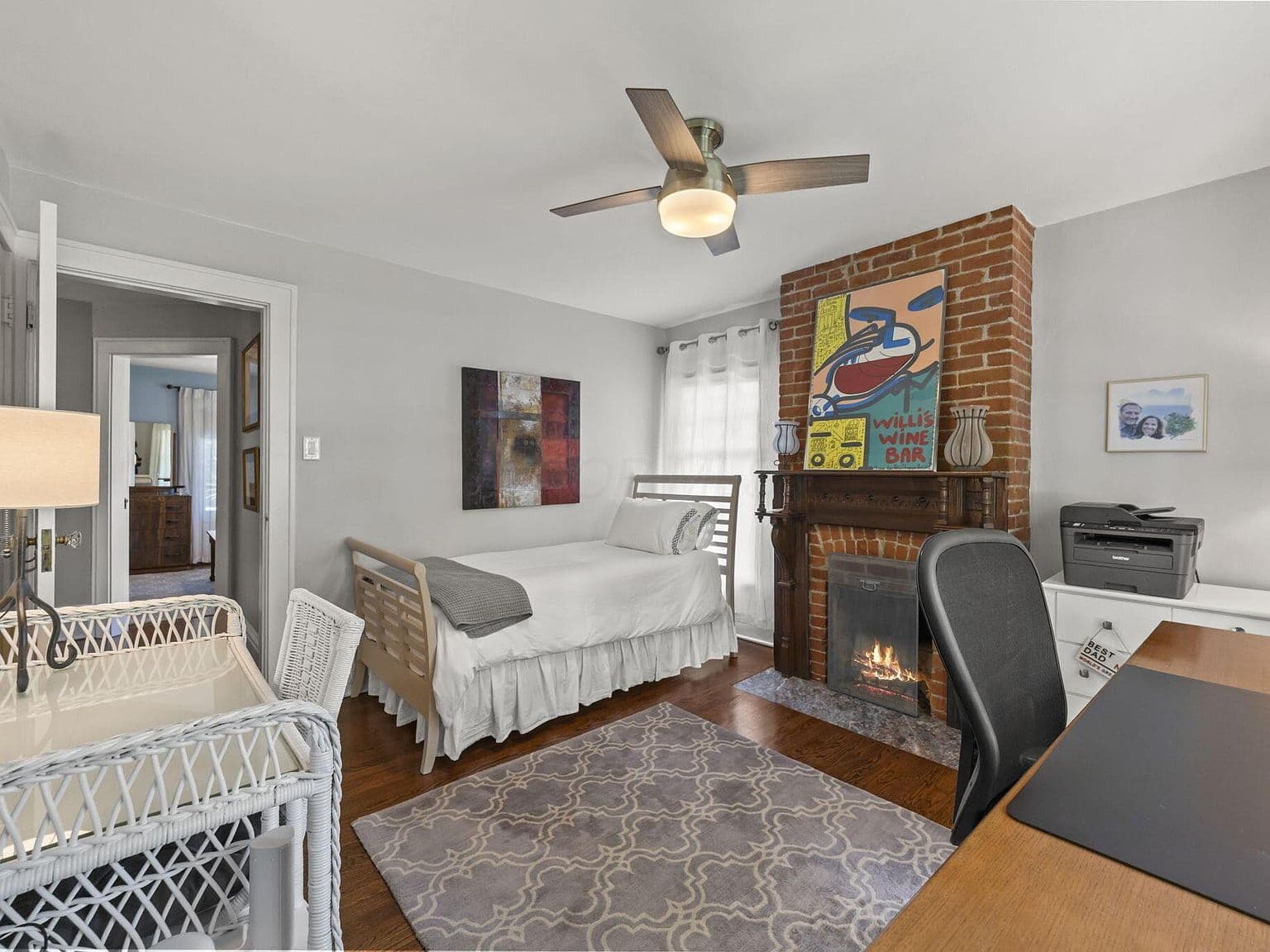 Bright workspace bedroom with brick fireplace focal point.