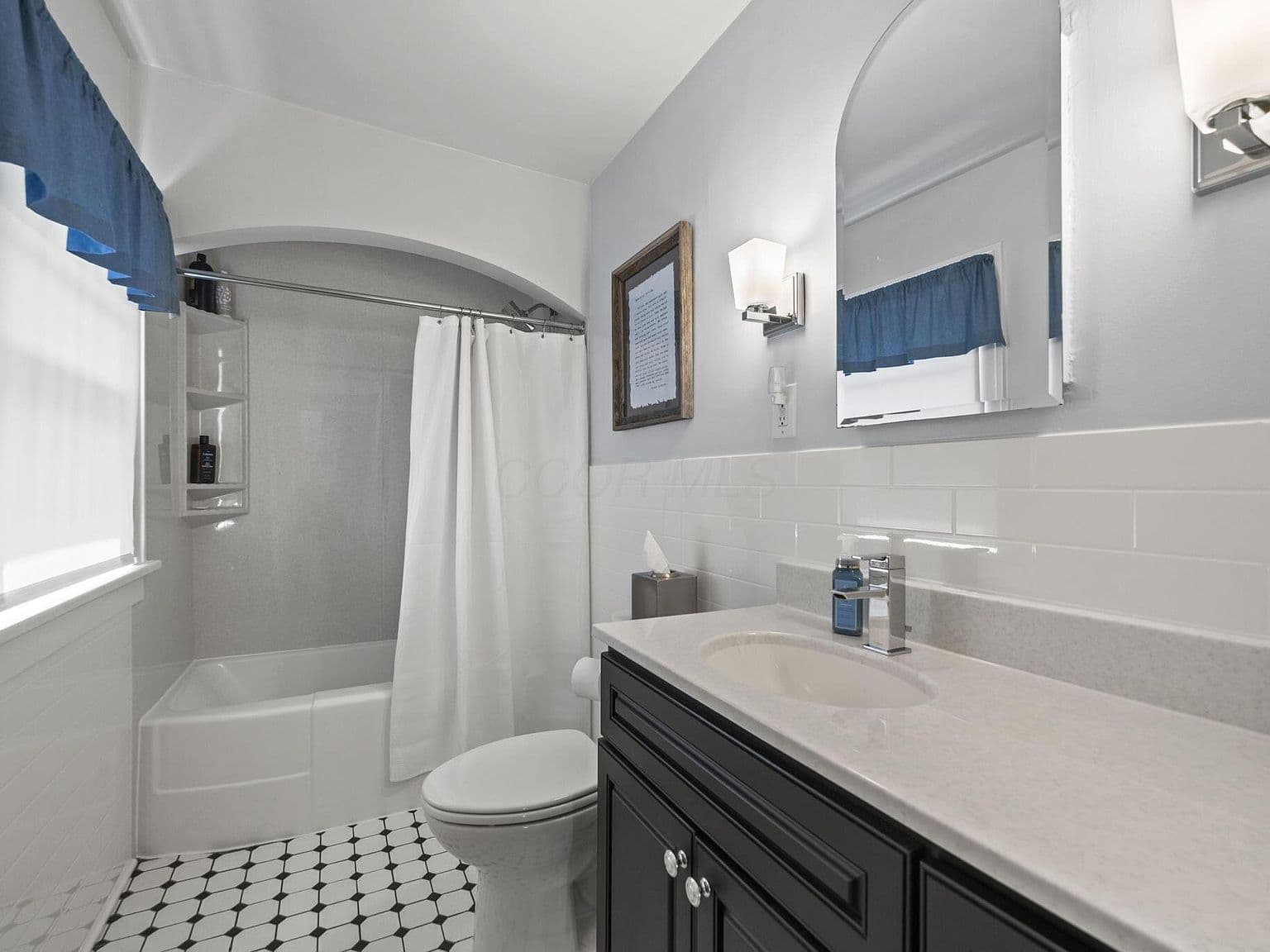 Updated full bath with sleek vanity and classic tile.
