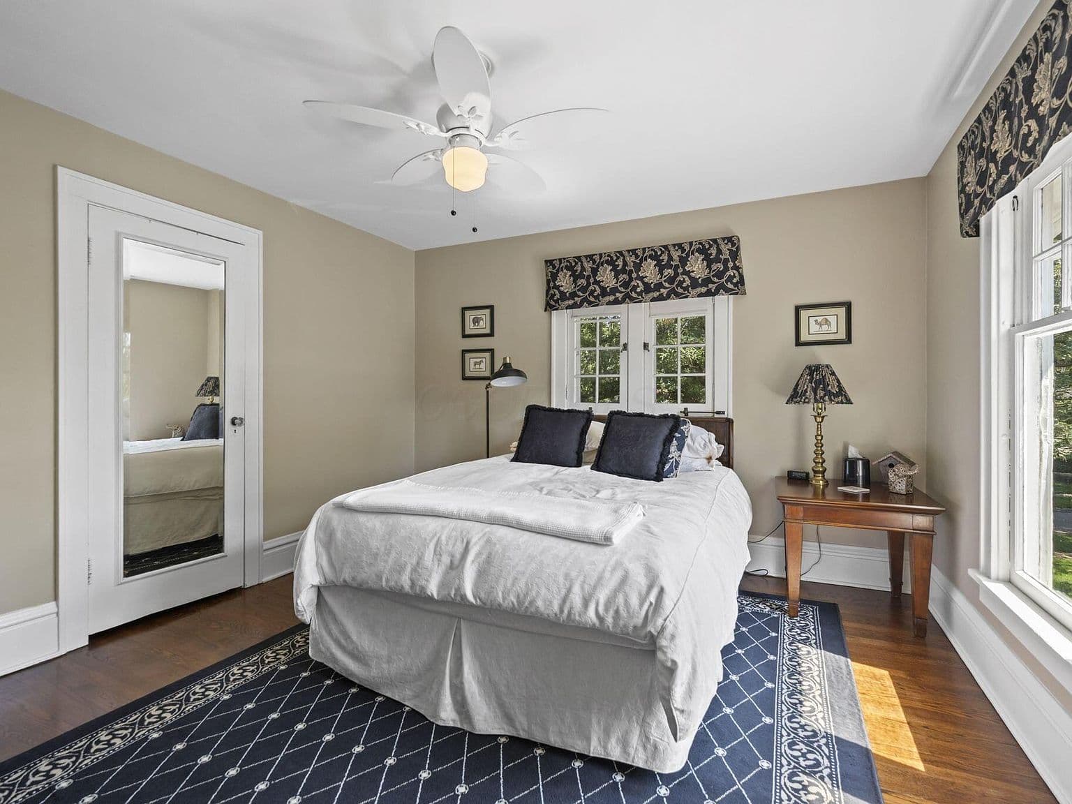 Bright bedroom with hardwood floors and sunny windows.