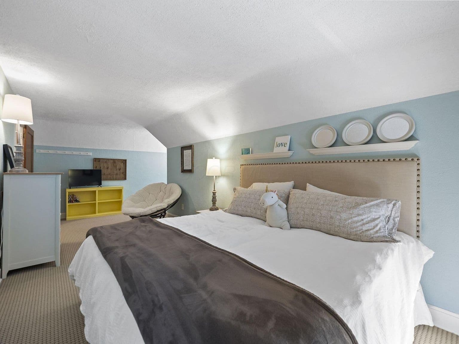 Spacious upper-level retreat with sitting area and built-ins.