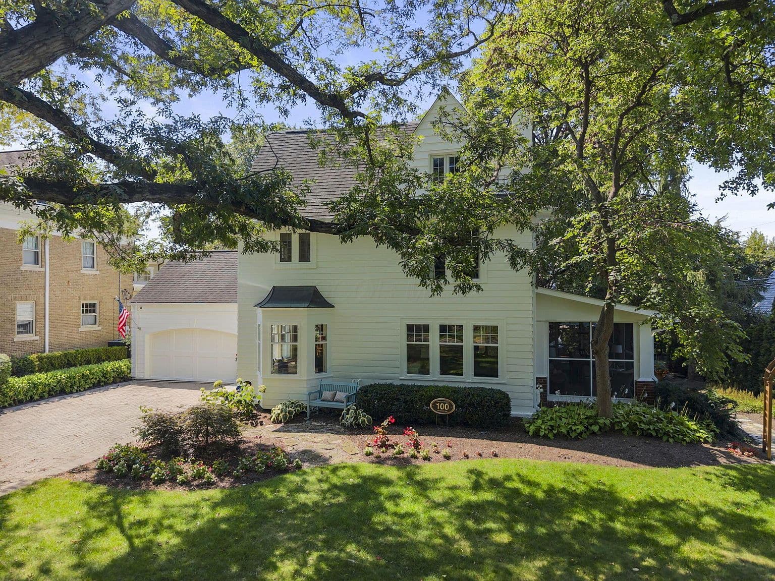 Picture-perfect yard with screened porch and lush landscaping.