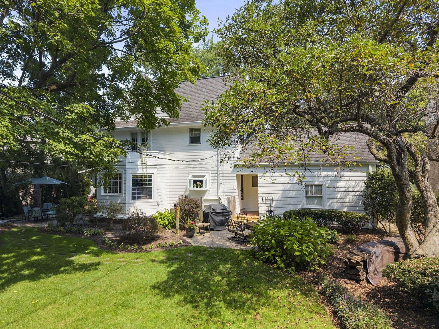 Private backyard patio surrounded by mature trees and gardens.