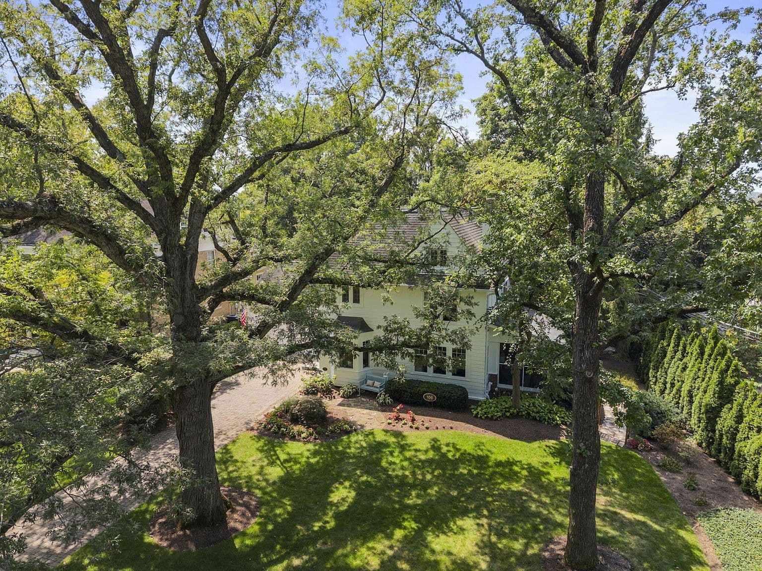 Aerial view showcasing lush landscaping and spacious corner lot.