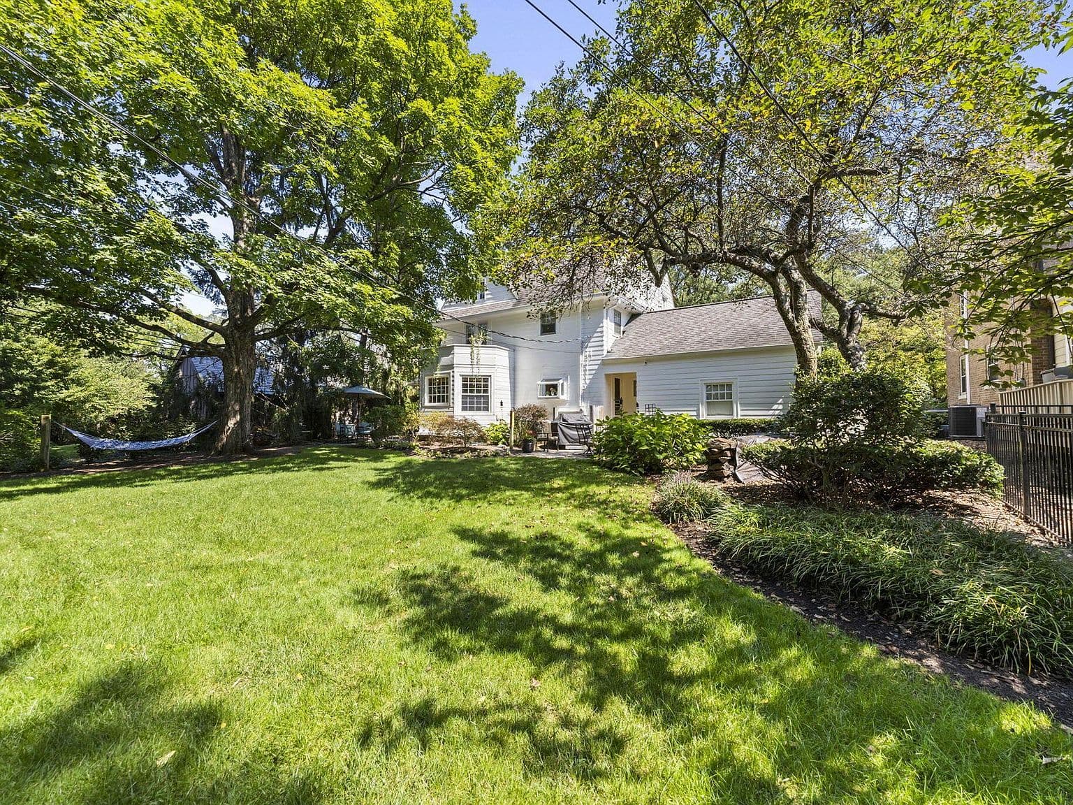 Classic rear exterior with lush landscaping and open lawn.