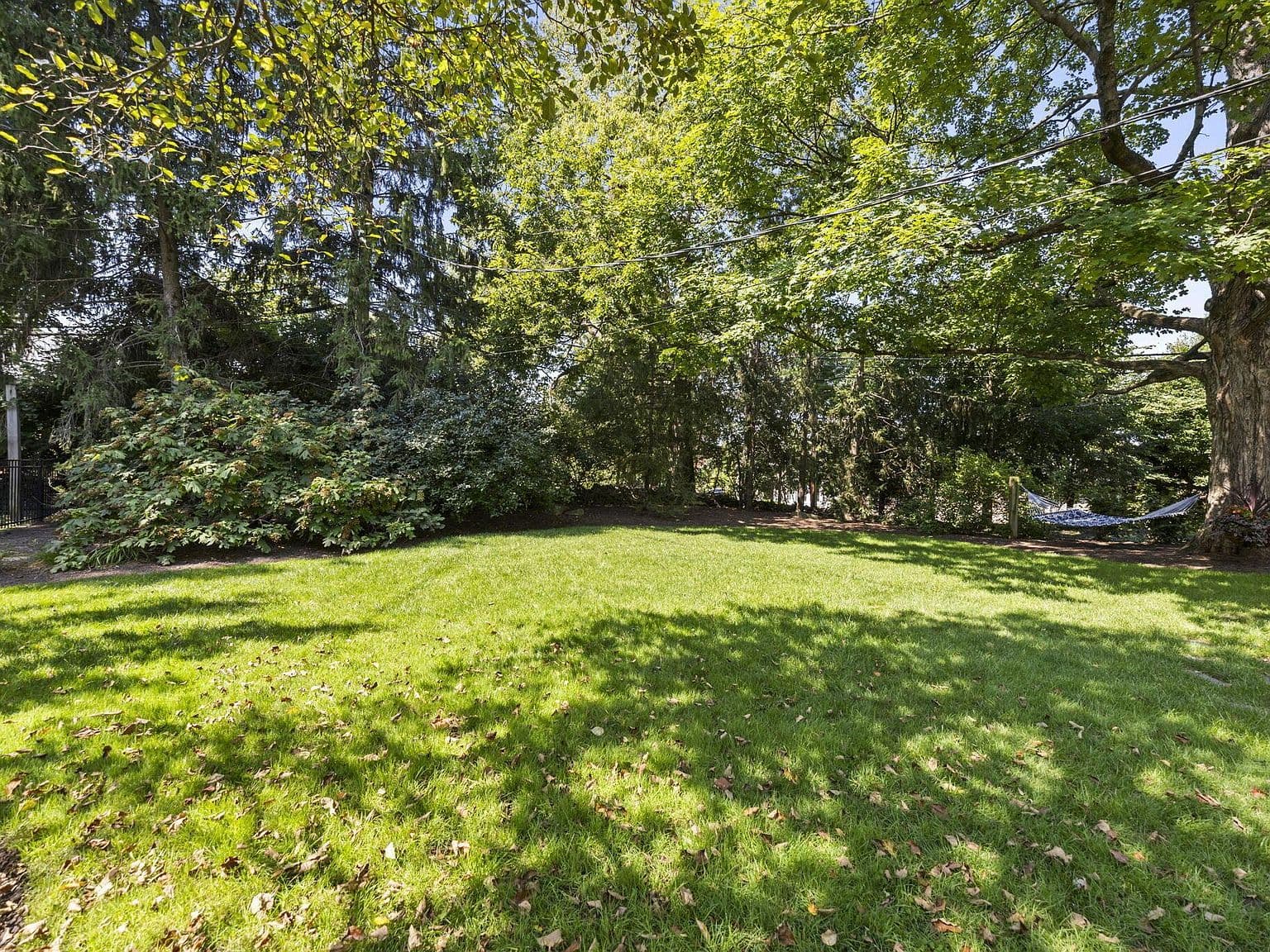 Private, tree-shaded backyard lawn for play and relaxation.
