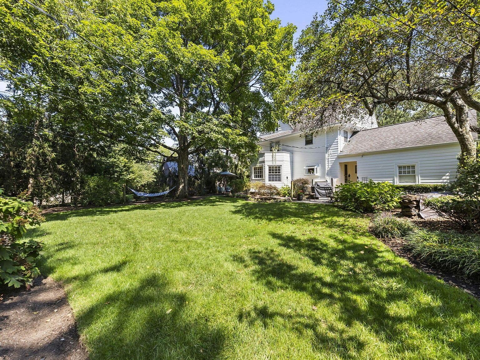 Expansive backyard retreat with hammock and entertaining space.