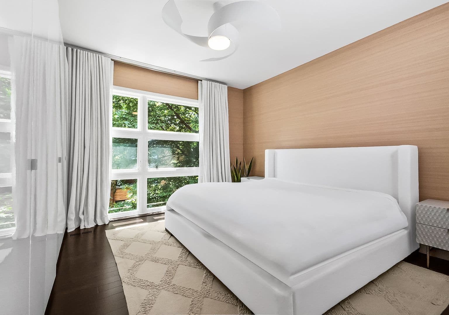 Bright primary bedroom sanctuary with oversized windows and bamboo floors.