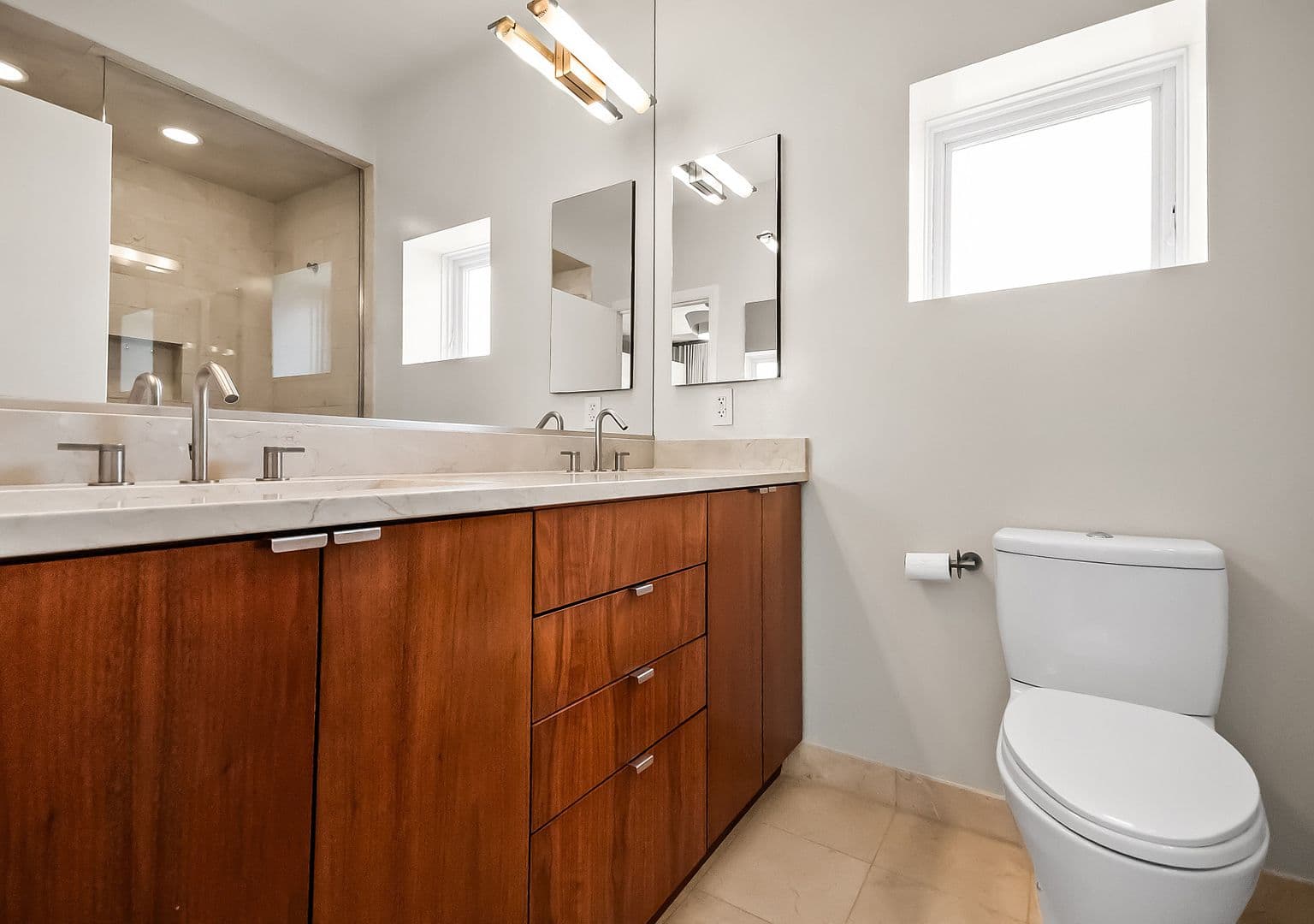 Sleek double-vanity bath with modern lighting and storage.