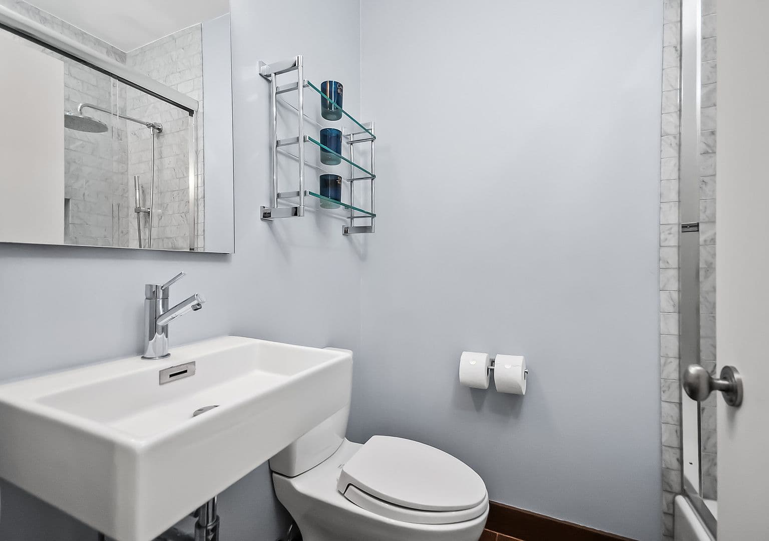 Stylish powder room with floating sink and marble accents.