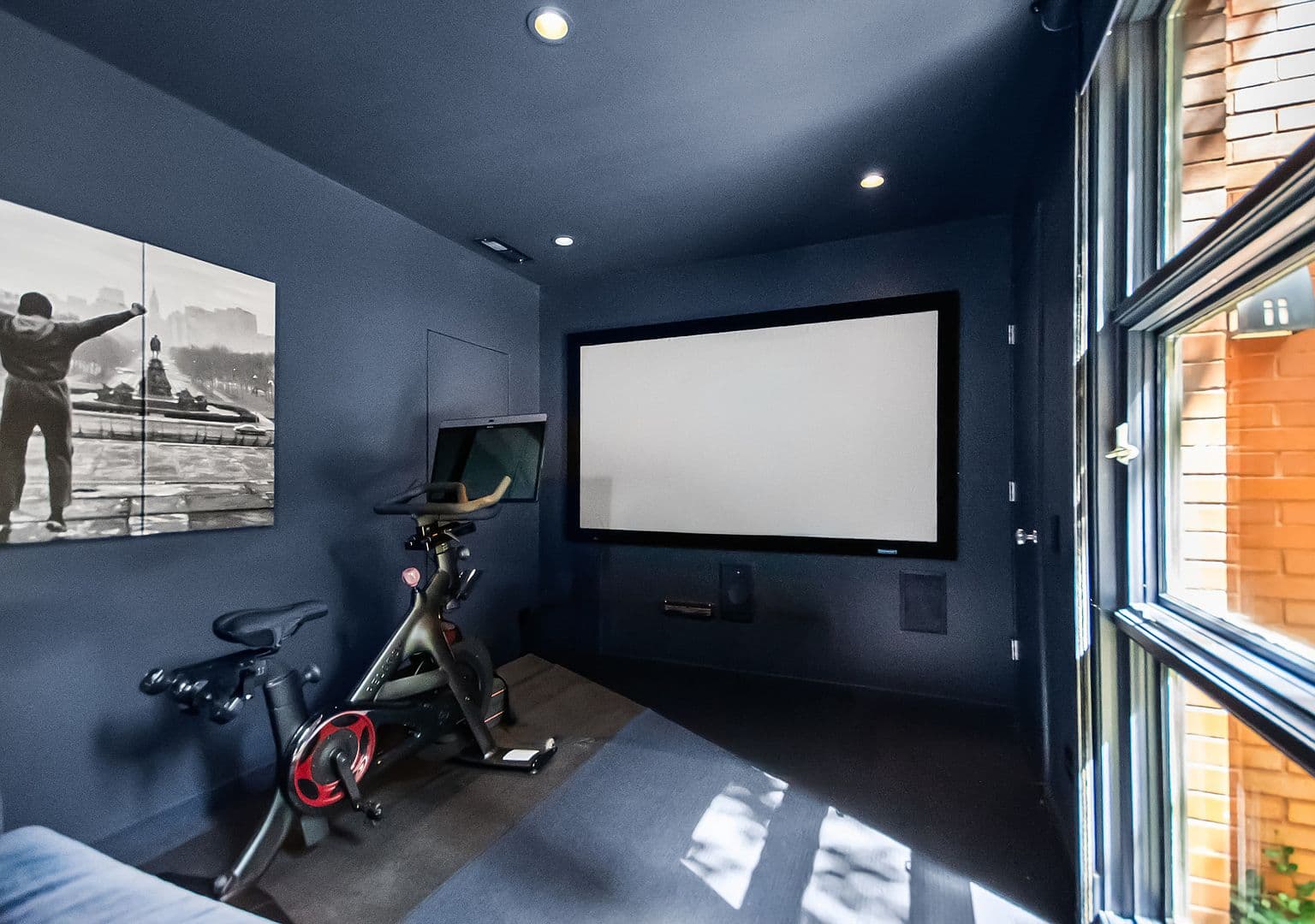 Dedicated home theater featuring big screen and Peloton space.