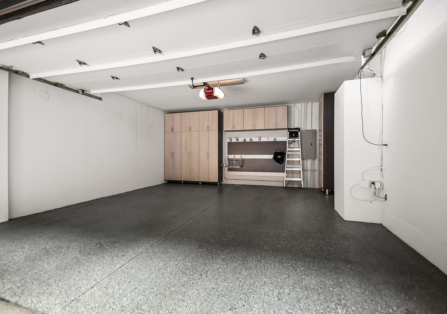 Attached two-car garage with built-in storage and workspace.
