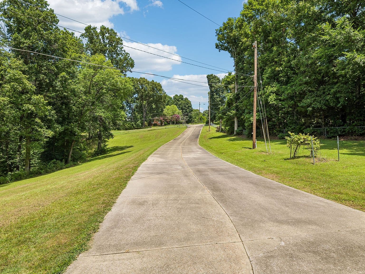 Long private drive through lush, tree-lined grounds.