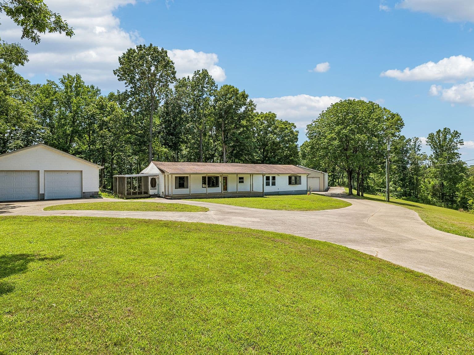 Wide driveway access to home, garage, and heated shop.