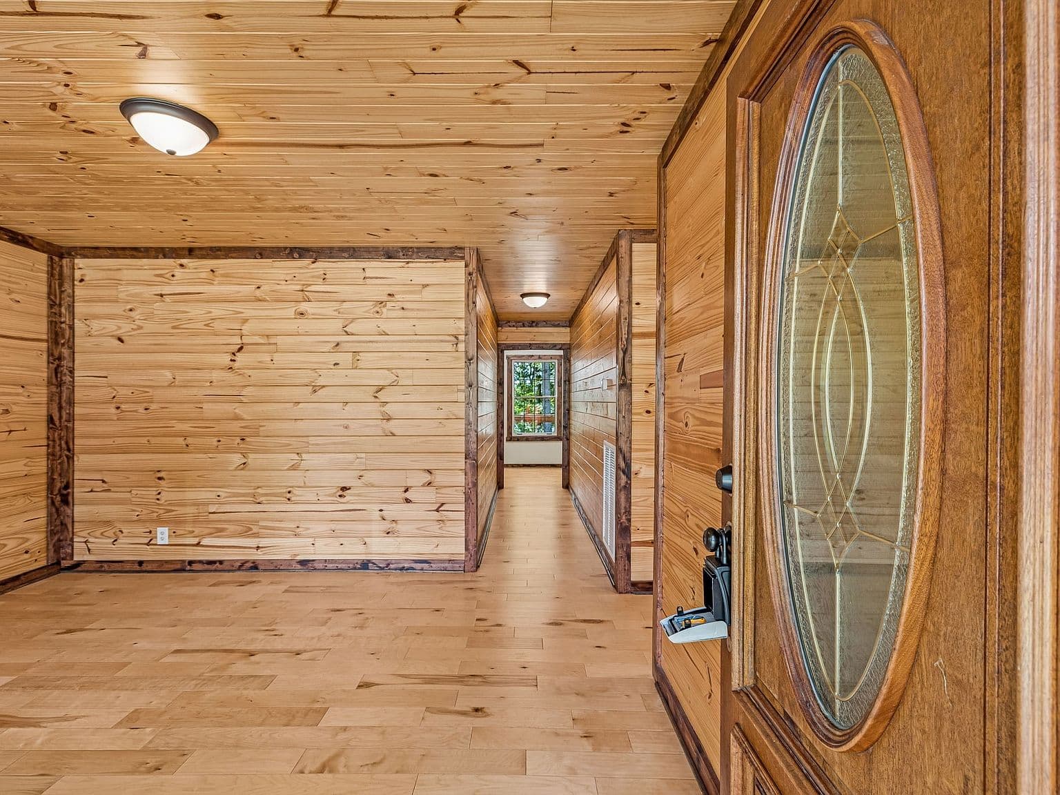 Warm knotty-pine entry sets a cozy, rustic tone.