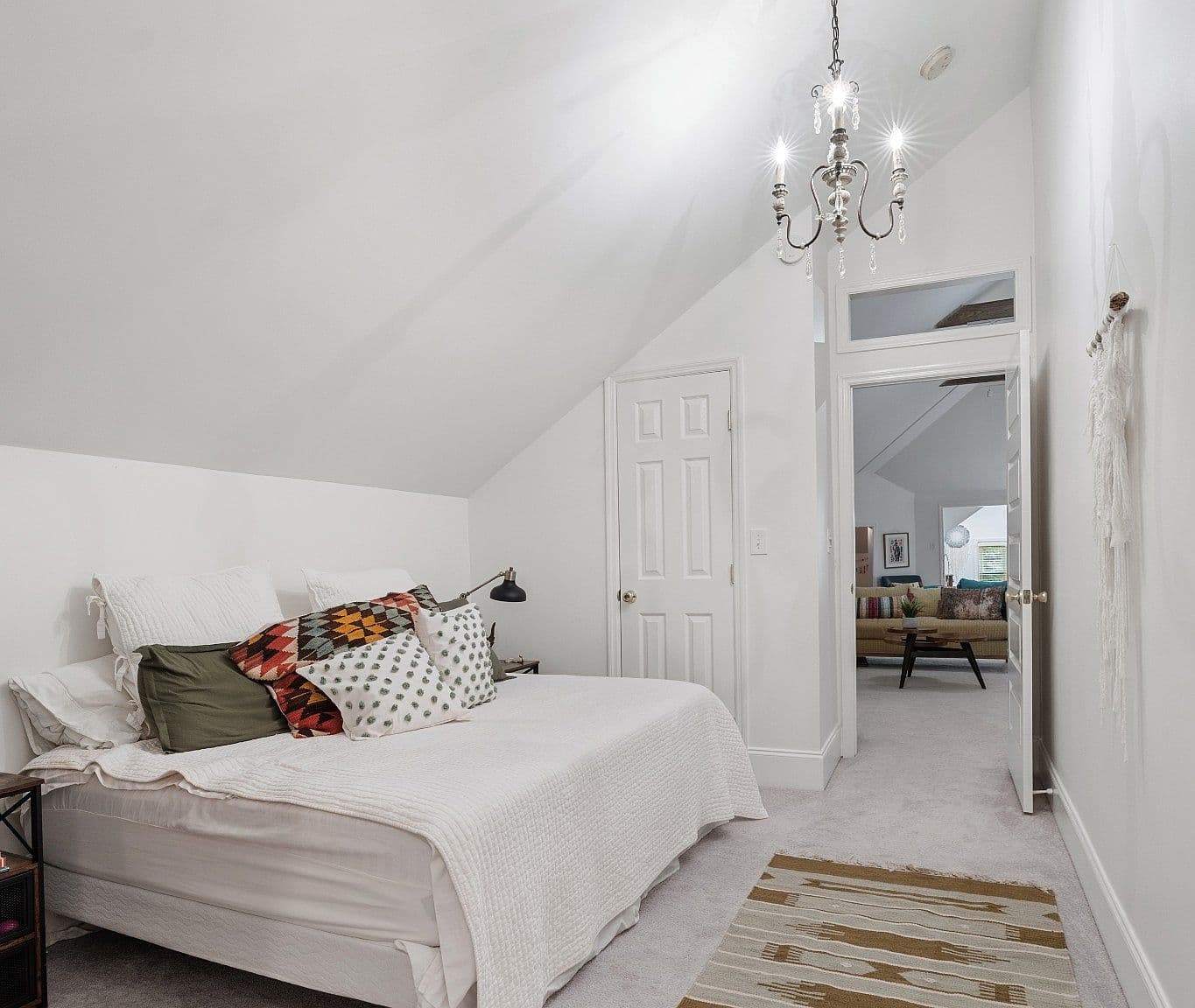 Bright bedroom retreat with vaulted ceiling and chandelier.