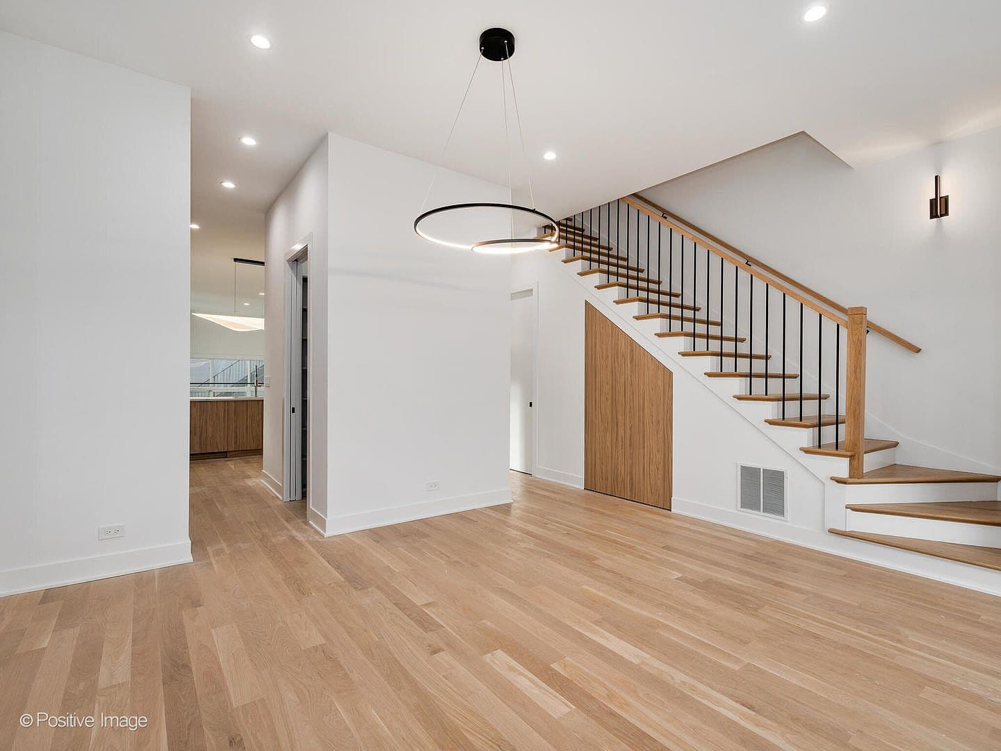 Open dining area with custom walnut under-stair storage
