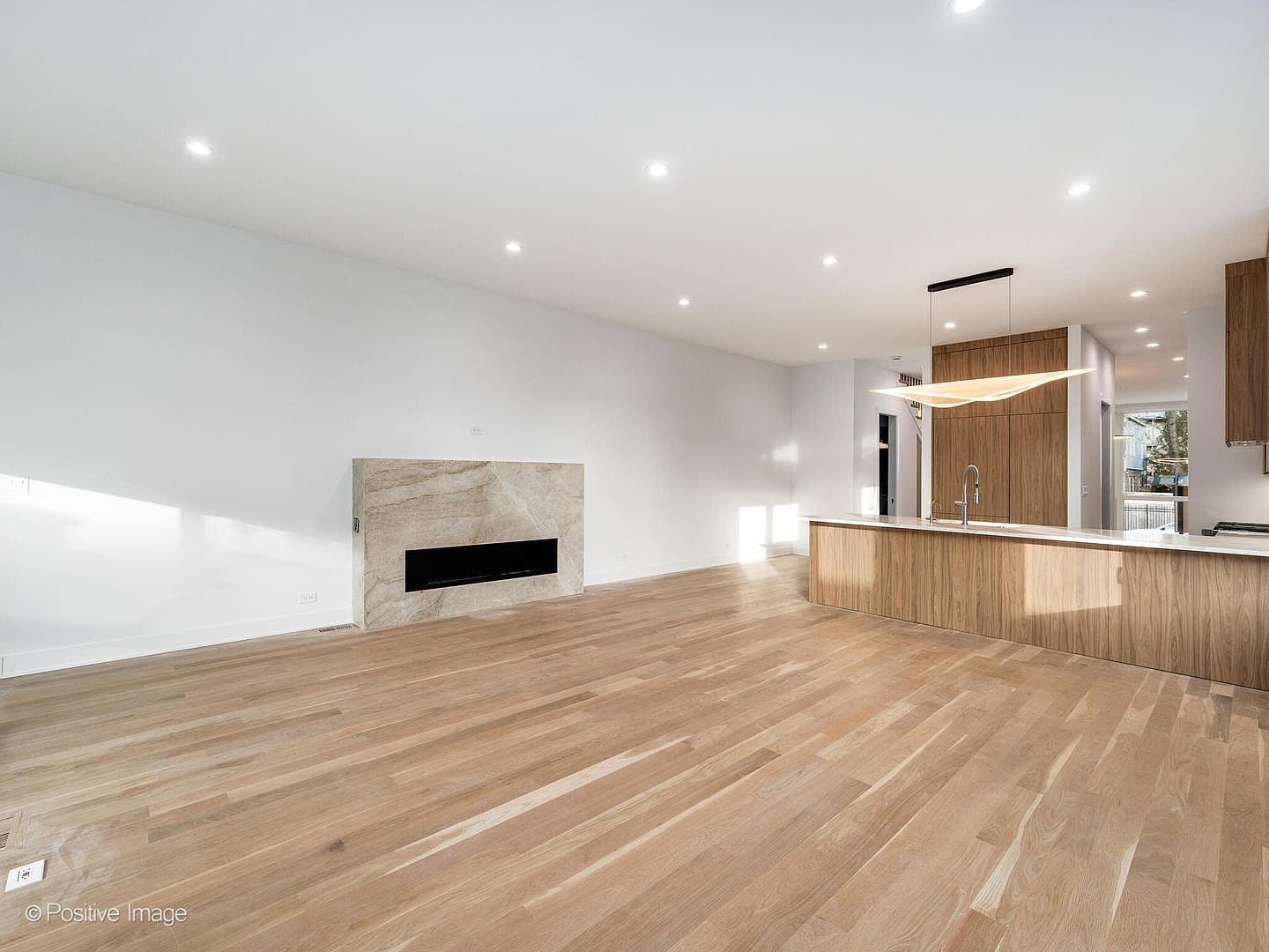 Open-concept great room flowing into the walnut kitchen
